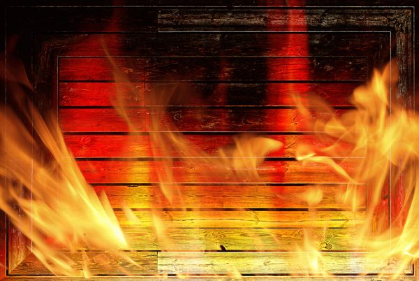 Wooden wall on fire with flames - Fire safety concept.